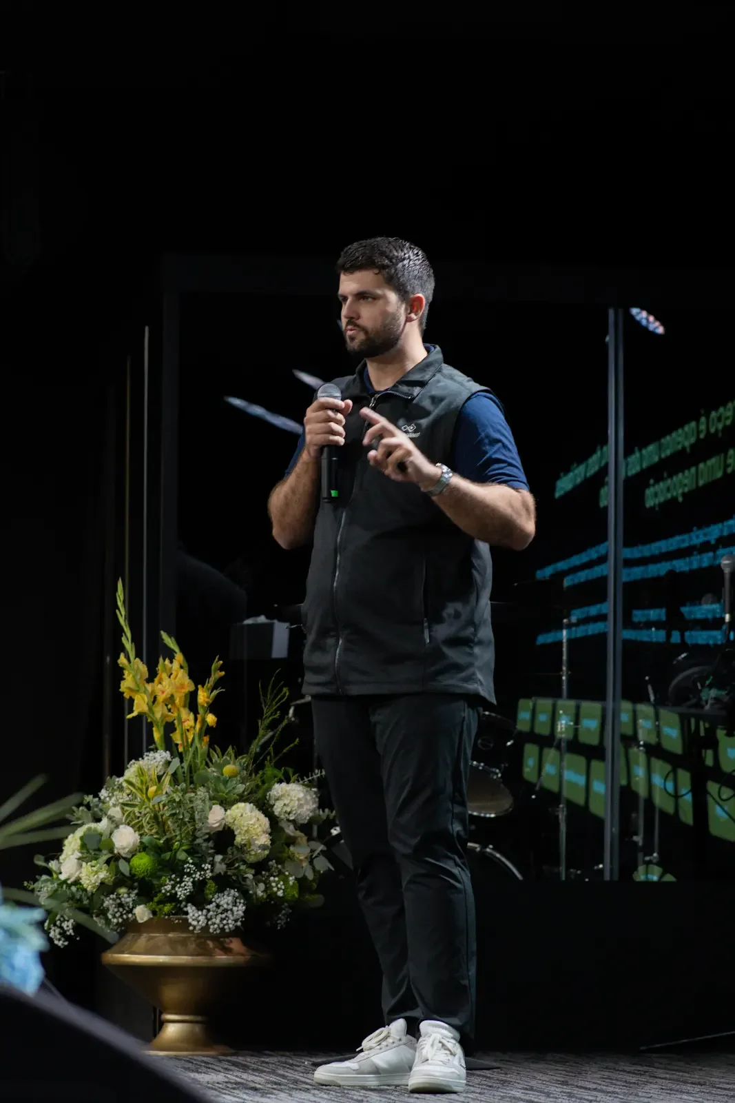 Rafael Bazilio falando ao microfone no palco do Lume Scale