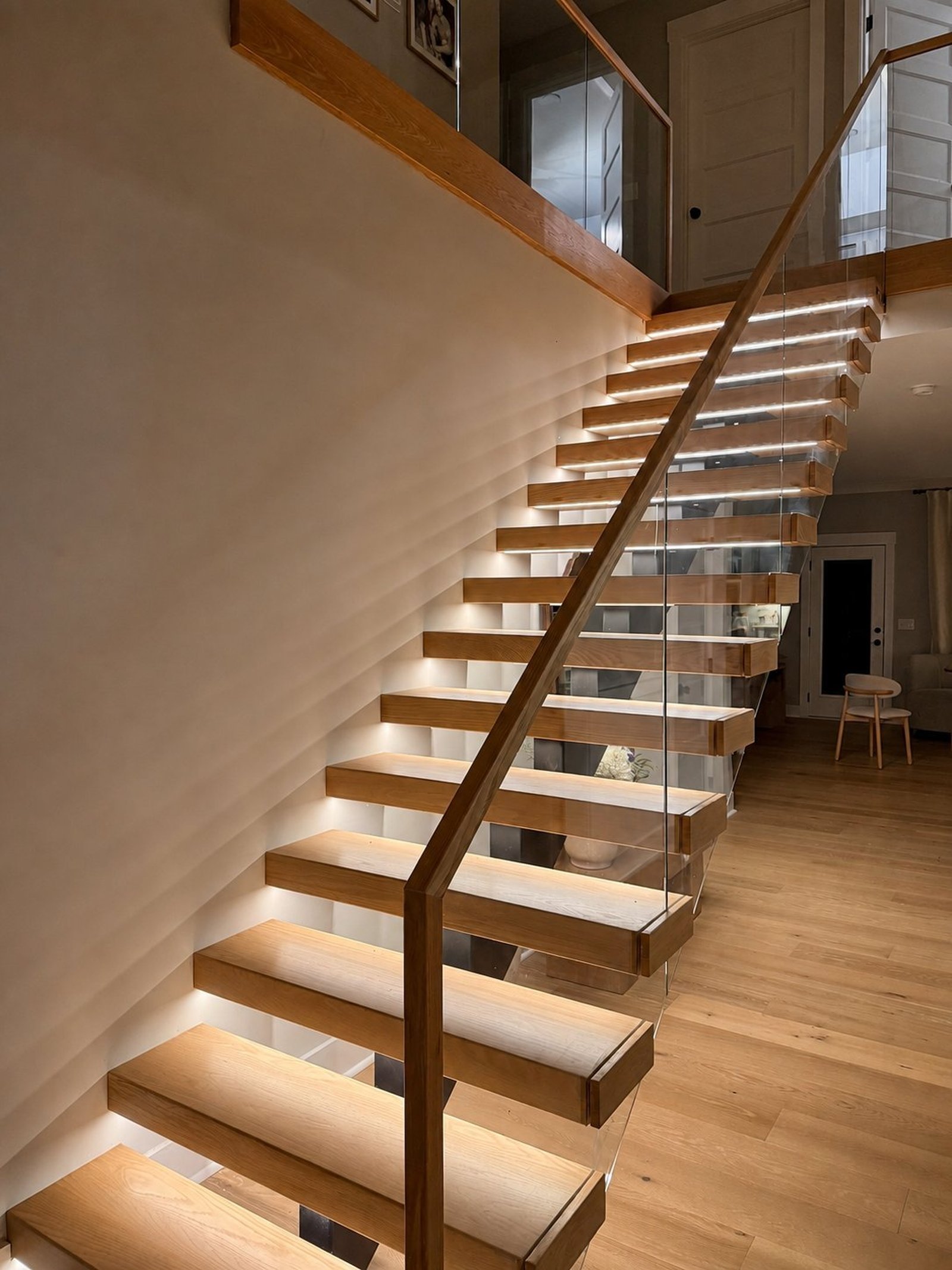 Escada flutuante da Dr. Stairs com guarda-corpo de vidro, degraus de madeira e estrutura metálica